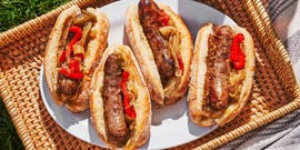 grilled bratwurst braised with beer in a pan with caramelized onions and bell peppers