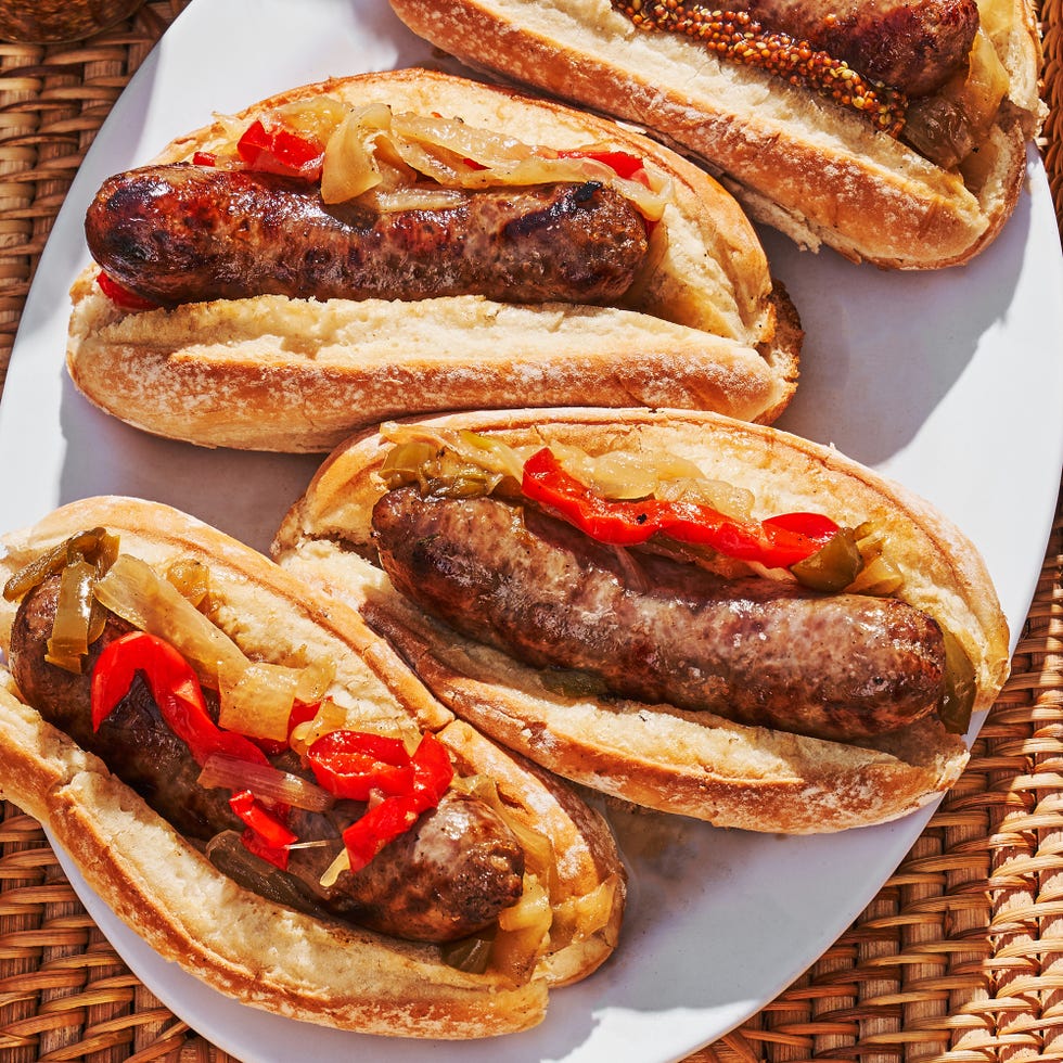 grilled bratwurst braised with beer in a pan with caramelized onions and bell peppers