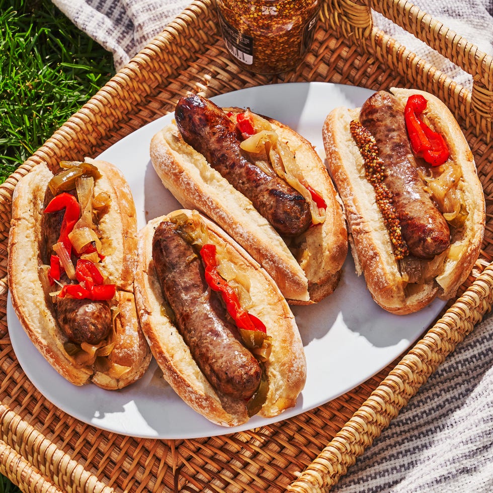 grilled bratwurst braised with beer in a pan with caramelized onions and bell peppers