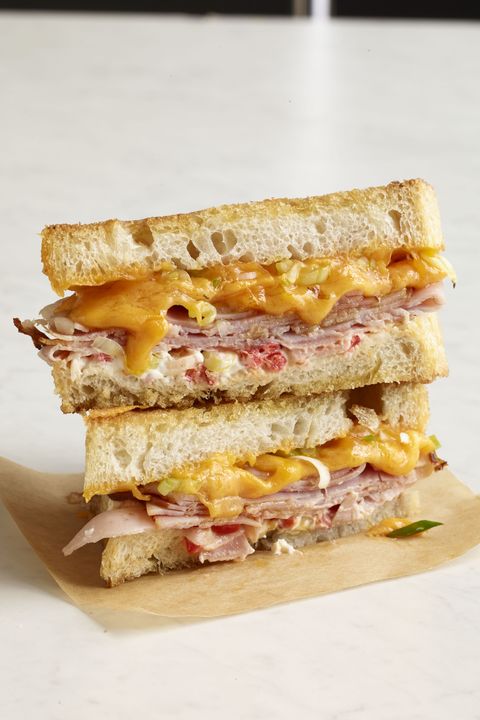 stacked halves of ham and pimento grilled cheese made with thick country bread served on parchment paper
