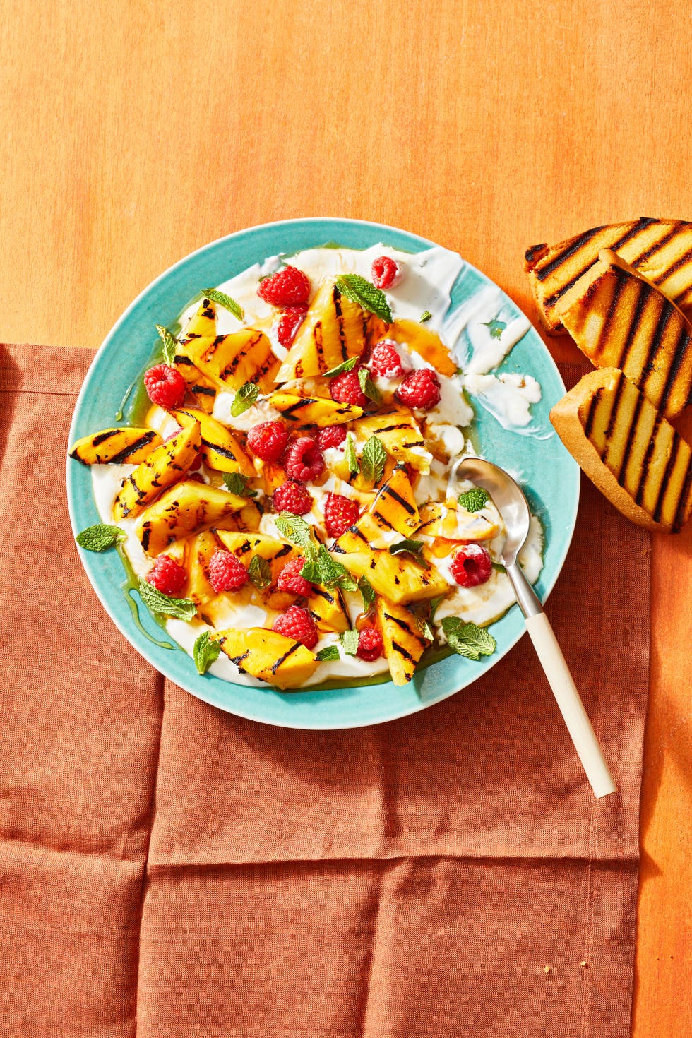 grilled fruit salad with vanilla yogurt on a blue plate