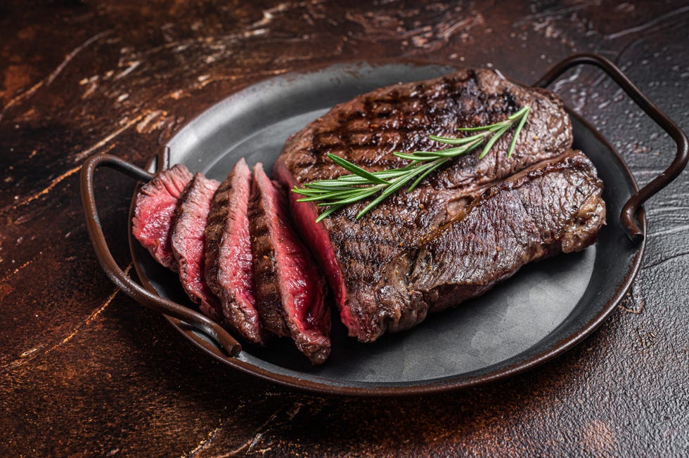 grilled medium rare top sirloin beef steak or rump steak on a steel tray dark background top view