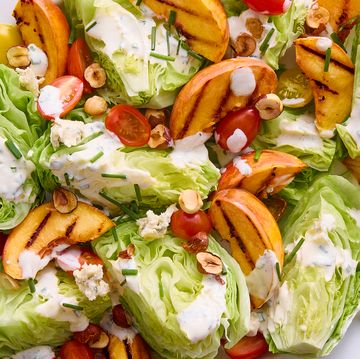 lettuce topped with grilled peach slices, tomatoes, toasted hazelnuts and creamy buttermilk dressing