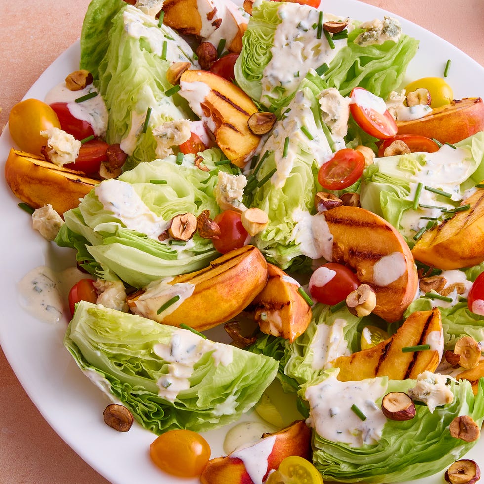 lettuce topped with grilled peach slices, tomatoes, toasted hazelnuts and creamy buttermilk dressing