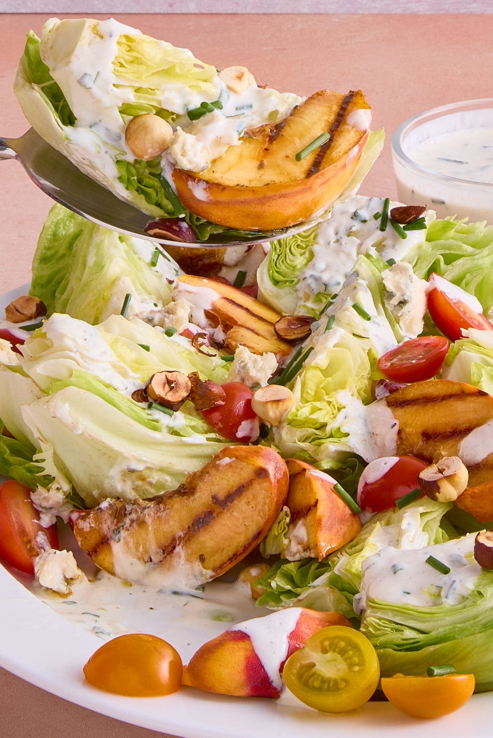 lettuce topped with grilled peach slices, tomatoes, toasted hazelnuts and creamy buttermilk dressing