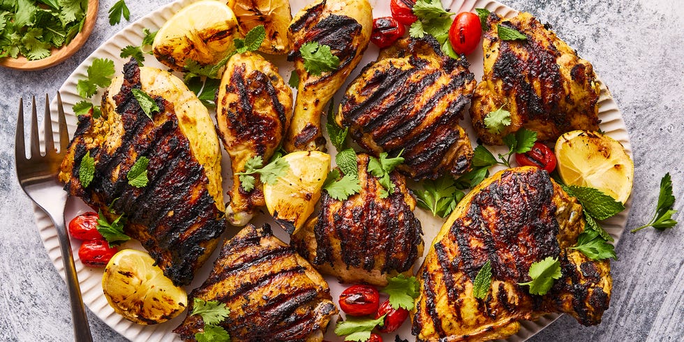 grilled chicken with grilled lemon wedges, tomatoes topped with parsley and mint