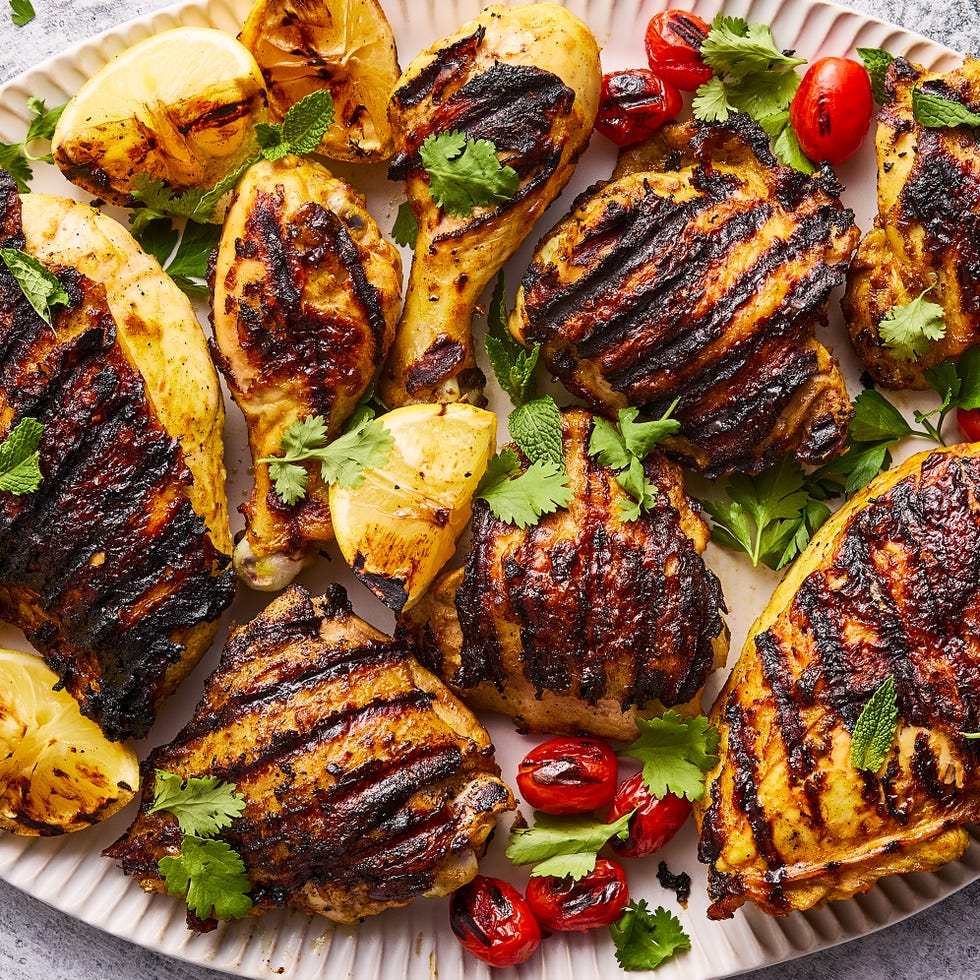 grilled chicken with grilled lemon wedges, tomatoes topped with parsley and mint