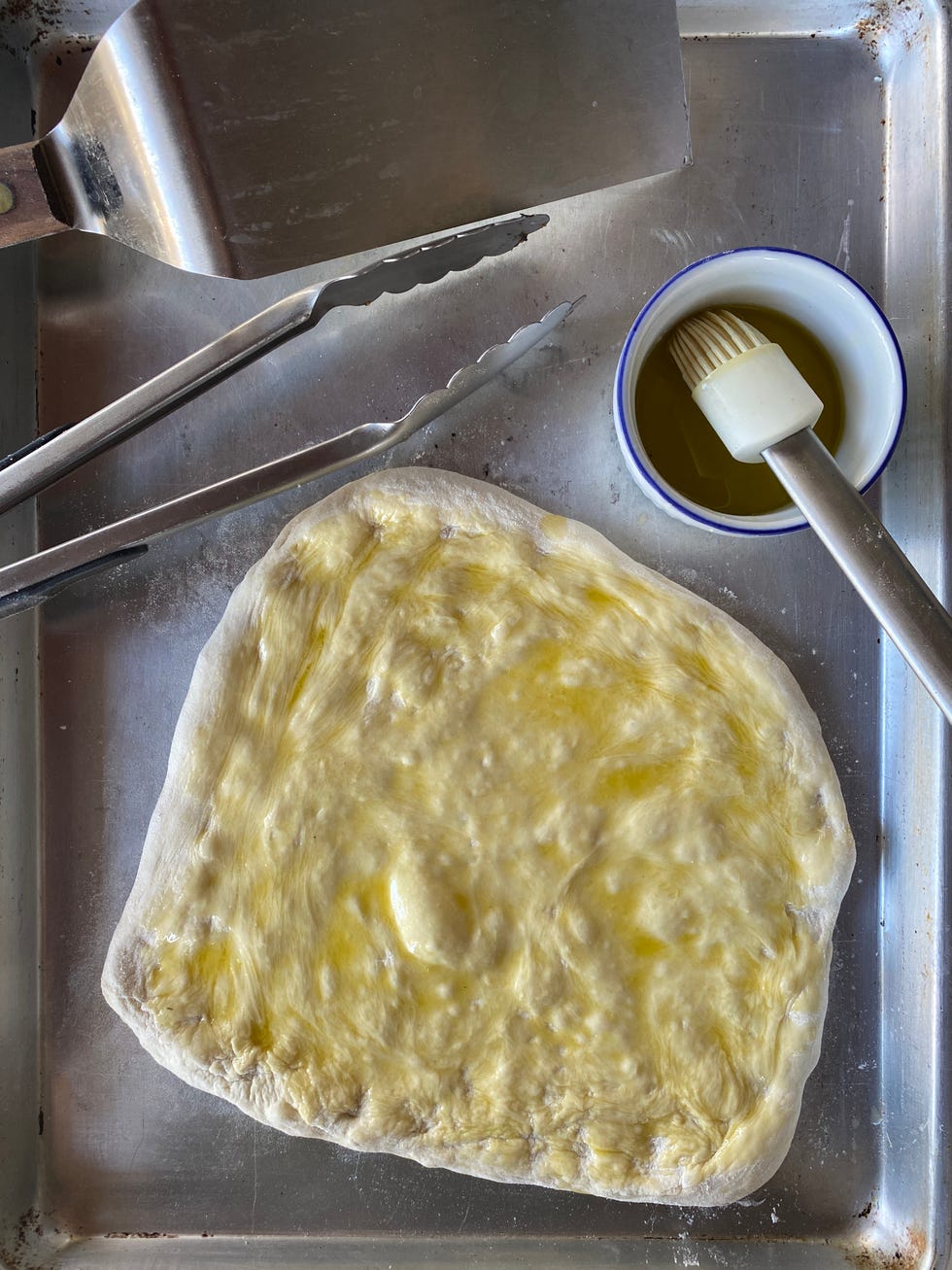 grilled pizza with olive oil on sheet pan