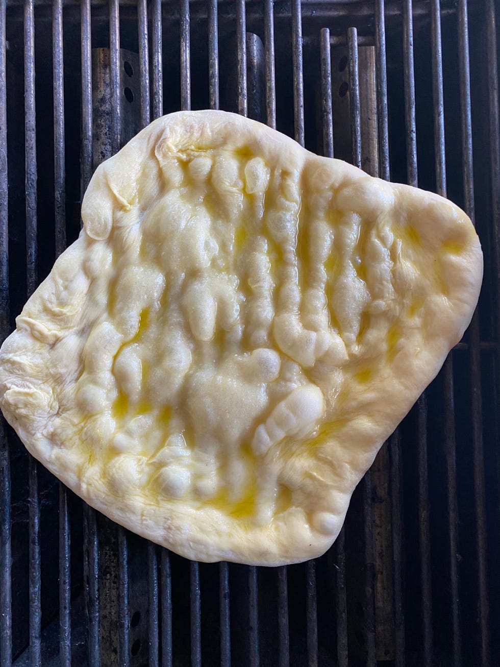 pizza dough on grill with oil