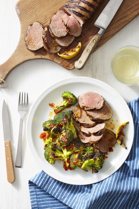 grilled pork with charred harissa broccoli on a white plate