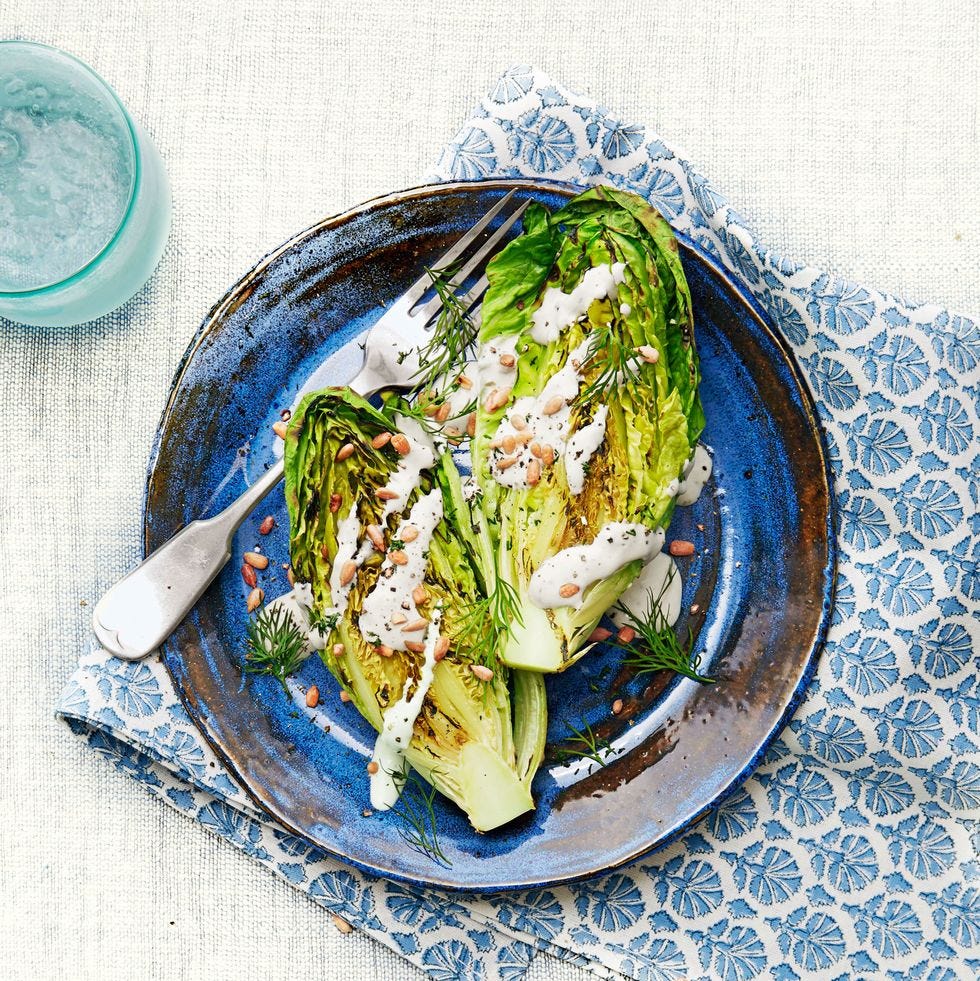 grilled romaine lettuce with creamy feta dressing on a blue plate