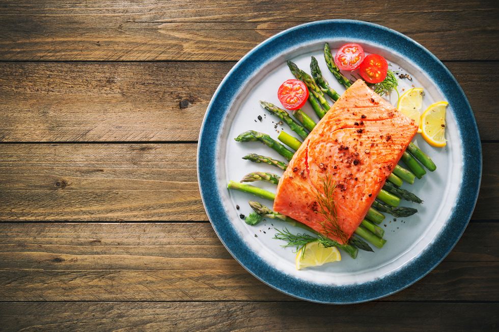 grilled salmon garnished with green asparagus and tomatoes