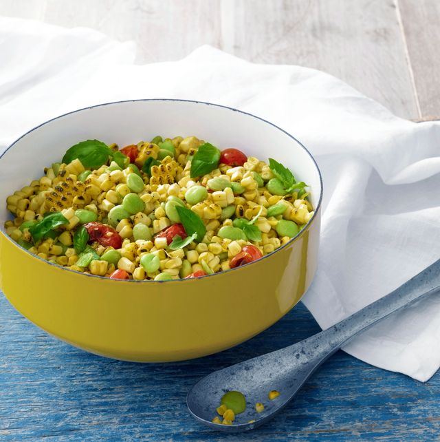 grilled succotash in a yellow enamel serving bowl with a vintage metal serving spoon