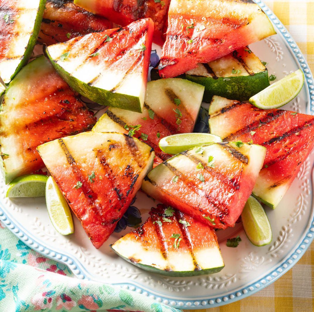 grilled watermelon with lime wedges on white platter