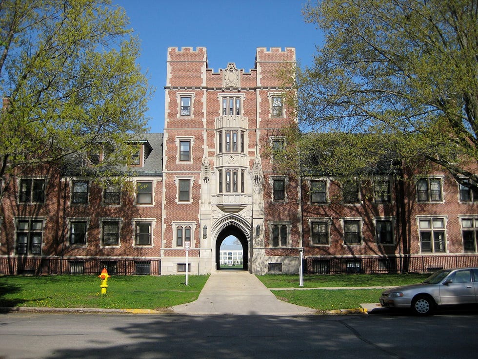 a large brick building with a yellow fire hydrant in front