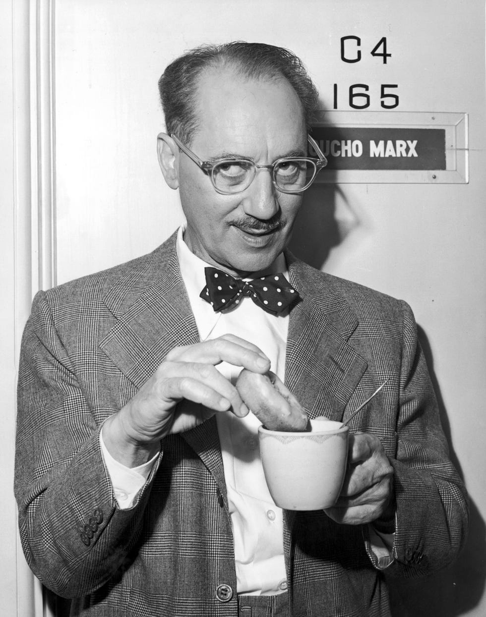 groucho marx mojando un donut en un café