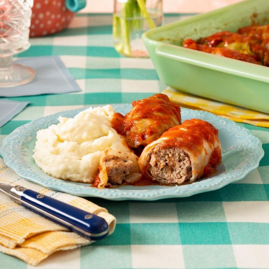 stuffed cabbage on blue plate with mashed potatoes
