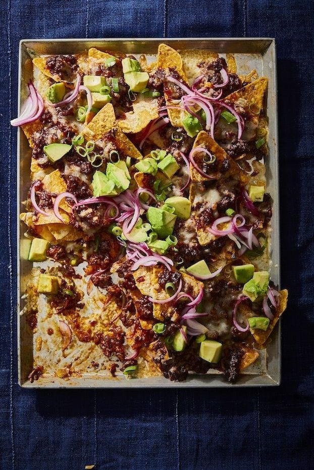 beef nachos with avocado and red onion on top