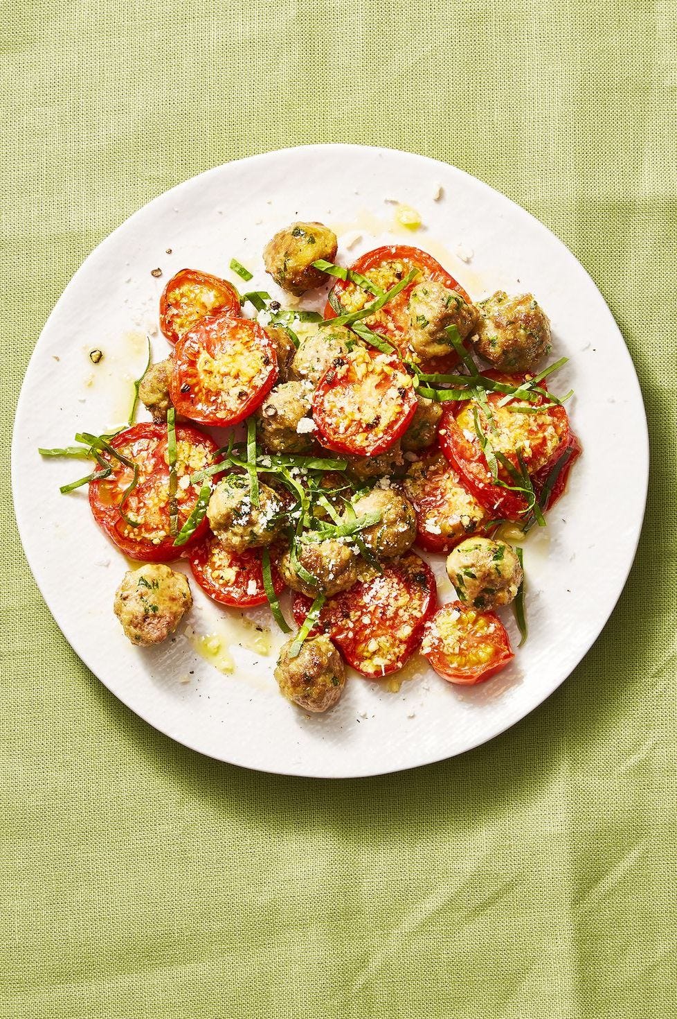 mini meatballs with roasted tomatoes on a white plate