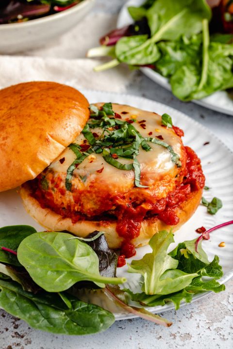 italian chicken burgers on plate with basil and side salad