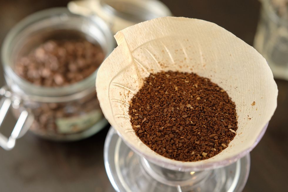 ground coffee beans and coffee beans in a preservation jar