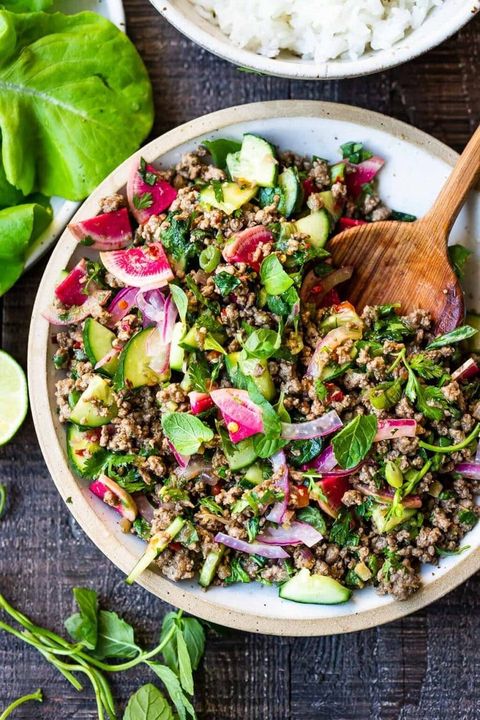 thai larb salad with cucumbers and radishes wooden spoon