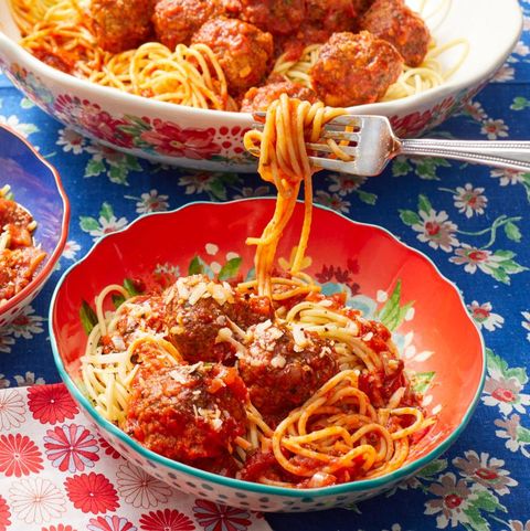 spaghetti and meatballs with fork twirling above