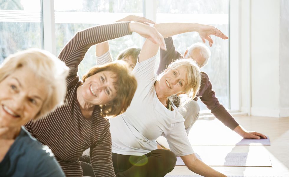 group of active seniors exercise in yoga class.