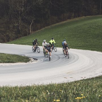 group of cyclist cycling up the hill on a curvy road