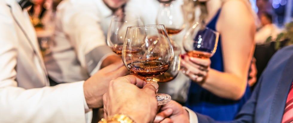 group of friends a toast to the cheers of cognac or brandy