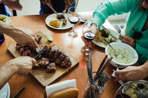 group of friends around the dining table while the meat is being carved this has been shot from above