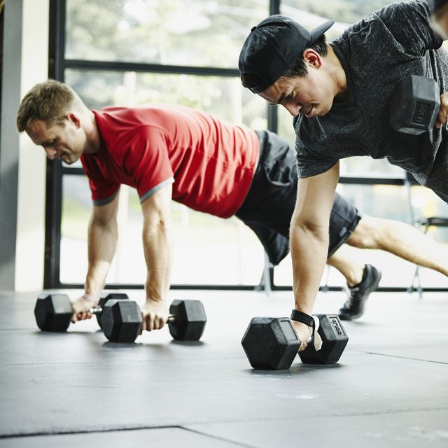 Group of friends doing pushups with dumbbells