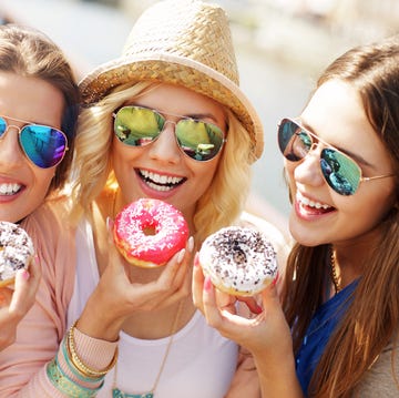 Group of friends eating donuts in the city