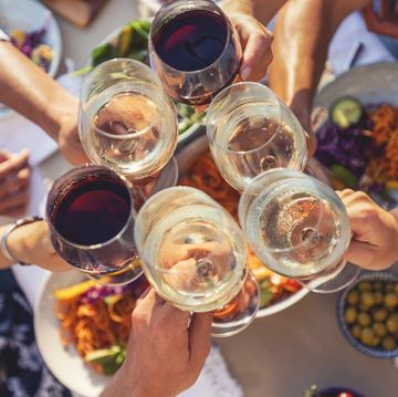 group of friends having a meal outdoors they are celebrating with a toast using wine