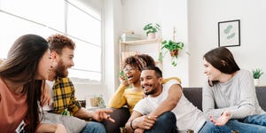 a group of friends having fun at home chatting, eating snacks and drinking beer