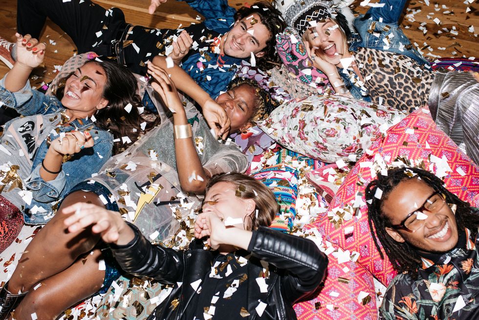 group of friends having fun with confetti on the floor