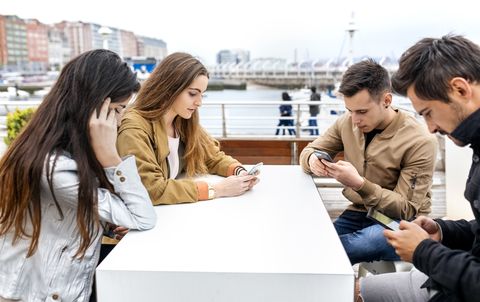 Group of friends using their smartphones