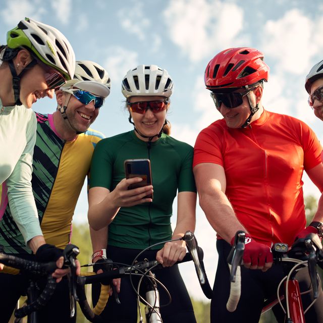 group of friends with road bicycles looking at smartphone