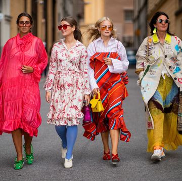 vier vrouwen lopen in kleurrijke kleding op straat