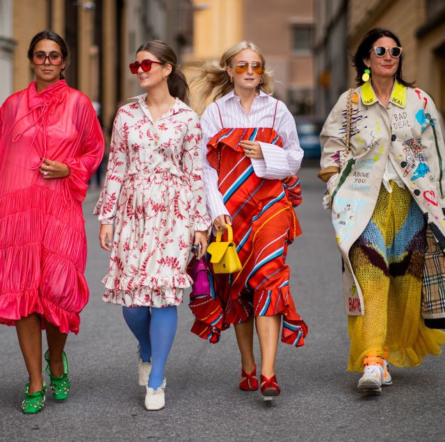 vier vrouwen lopen in kleurrijke kleding op straat