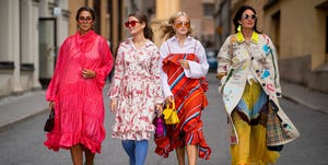 vier vrouwen lopen in kleurrijke kleding op straat