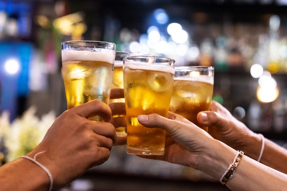 group of happy friends drinking and toasting beer at brewery bar restaurant friendship concept with young people having fun together at cool vintage pub focus on middle pint glass high iso image
