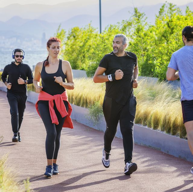 group of people jogging in a park