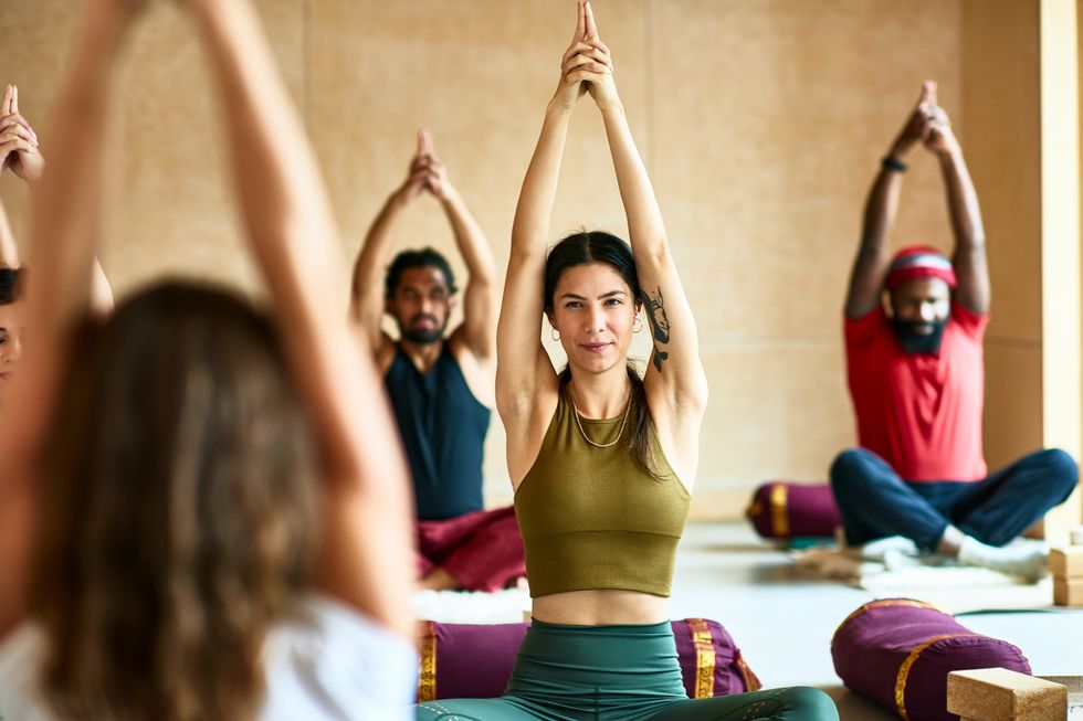group of people with arms raised in yoga position