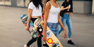 Group of teenage girls carrying skateboards
