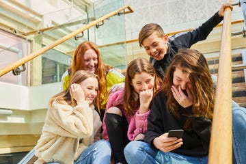 group of teenage girls in a shopping mall, checking their mobile phones