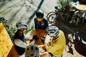 group of women cyclists taking a break and chatting at an urban cafe outdoor cycling lifestyle active urban life concept