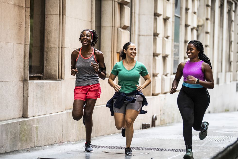group of women running Rosa through urban area