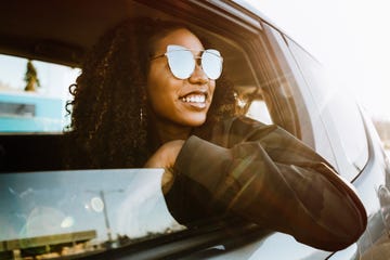 group of young adults having fun riding in car