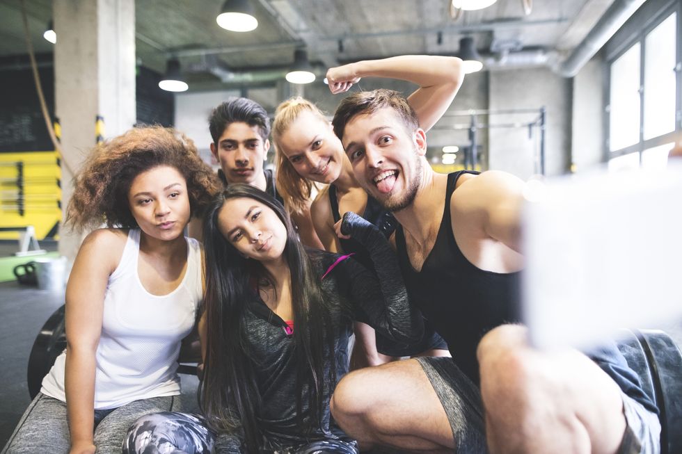 Group of young people posing for a selfie in gym